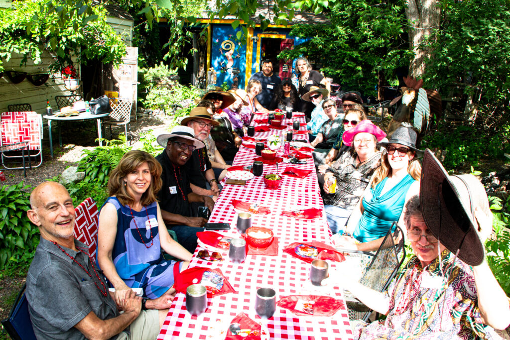 Donors sitting at a table outdoors, smiling for the camera at ACW's 2022 Annual Chowdah Feast